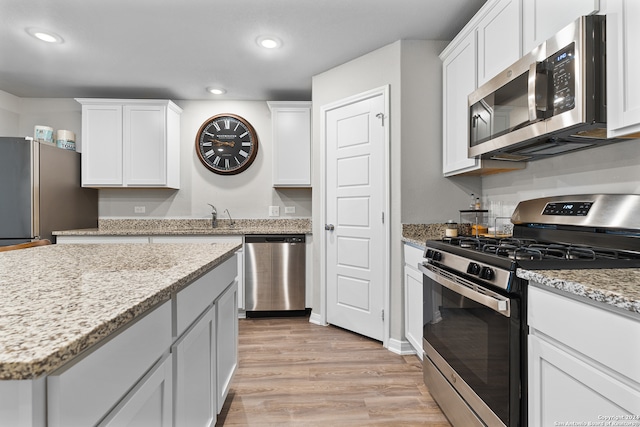 kitchen featuring white cabinets, light hardwood / wood-style floors, and appliances with stainless steel finishes