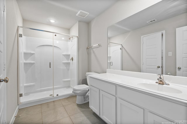 bathroom with tile patterned flooring, vanity, toilet, and a shower with shower door