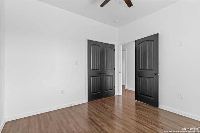 unfurnished bedroom featuring dark hardwood / wood-style floors and ceiling fan