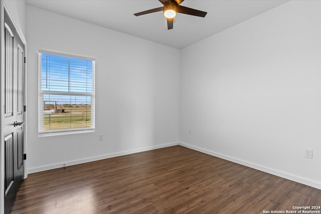 empty room with ceiling fan and dark hardwood / wood-style flooring