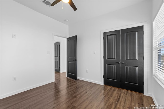 unfurnished bedroom featuring ceiling fan, a closet, and dark wood-type flooring