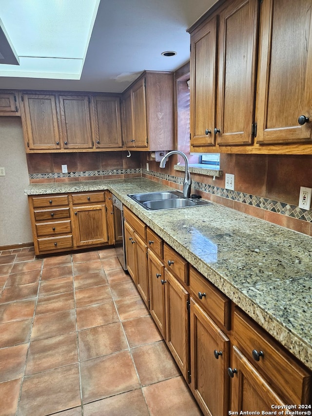 kitchen with dishwasher, tasteful backsplash, and sink