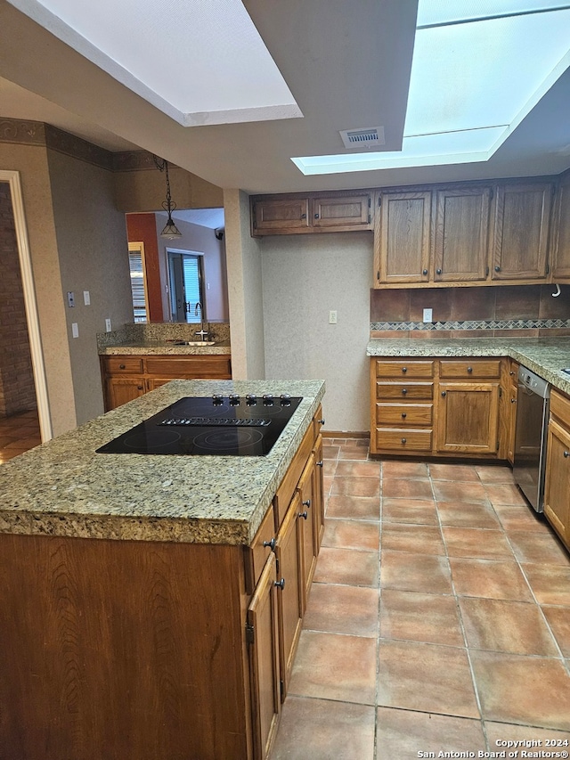 kitchen with sink, hanging light fixtures, stainless steel dishwasher, light stone countertops, and black electric cooktop