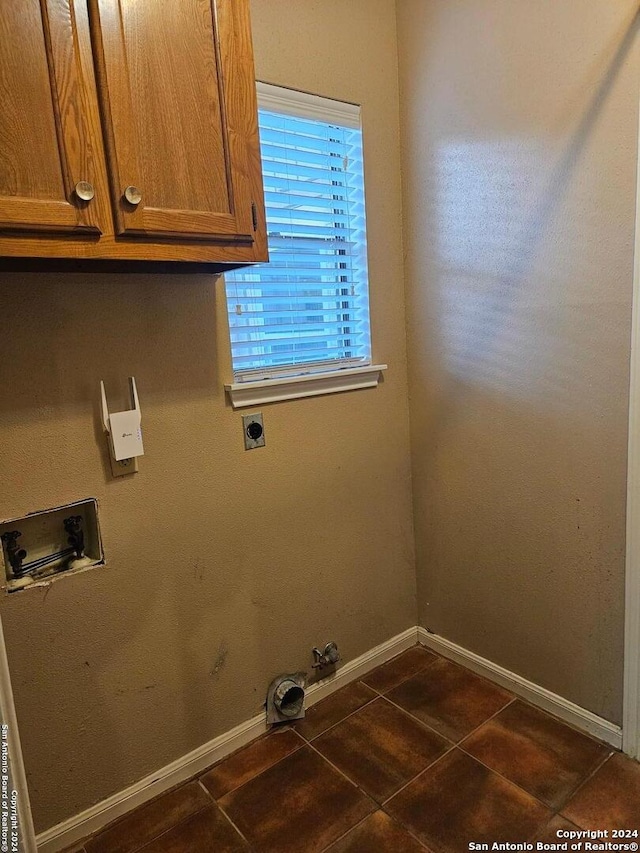 laundry room with cabinets, hookup for a washing machine, dark tile patterned floors, electric dryer hookup, and hookup for a gas dryer