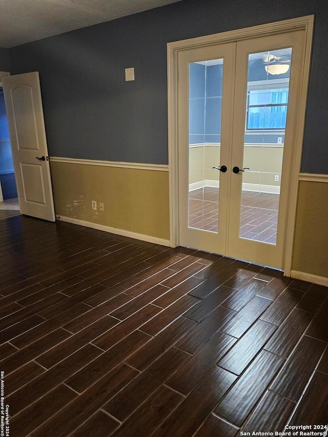 empty room with french doors and dark wood-type flooring