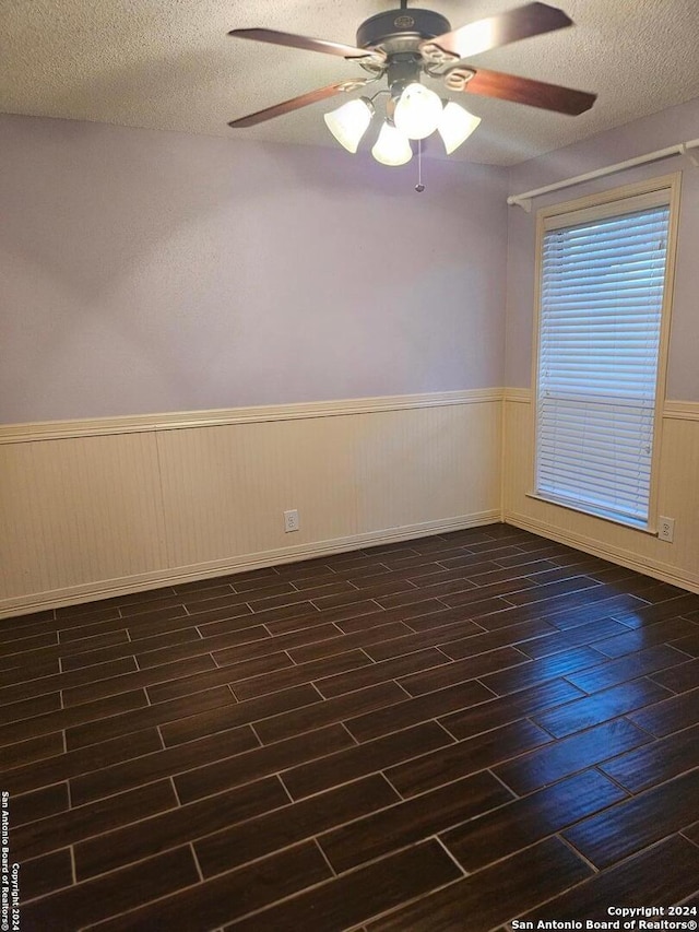 spare room with ceiling fan, dark hardwood / wood-style flooring, and a textured ceiling