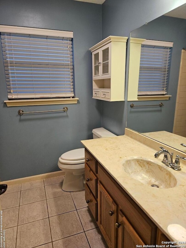 bathroom featuring tile patterned flooring, vanity, and toilet