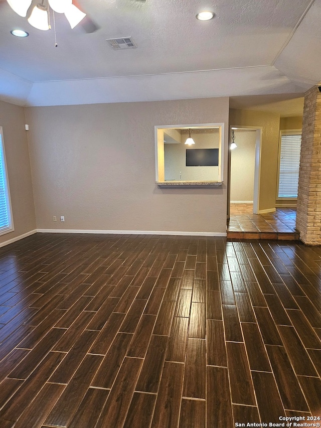 unfurnished room with a textured ceiling, ceiling fan, and dark hardwood / wood-style floors