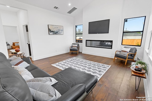 living room with dark hardwood / wood-style flooring and high vaulted ceiling