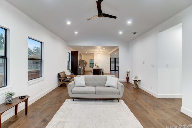 living room with wood-type flooring, ceiling fan, and lofted ceiling