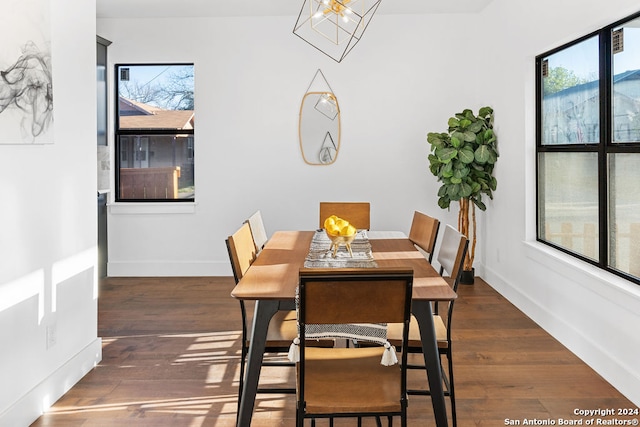 dining space featuring dark hardwood / wood-style floors and a notable chandelier