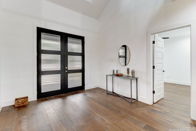 entryway featuring french doors, lofted ceiling, and hardwood / wood-style flooring