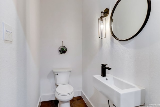 bathroom featuring sink, hardwood / wood-style floors, and toilet