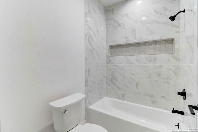 bathroom featuring tiled shower / bath combo and toilet