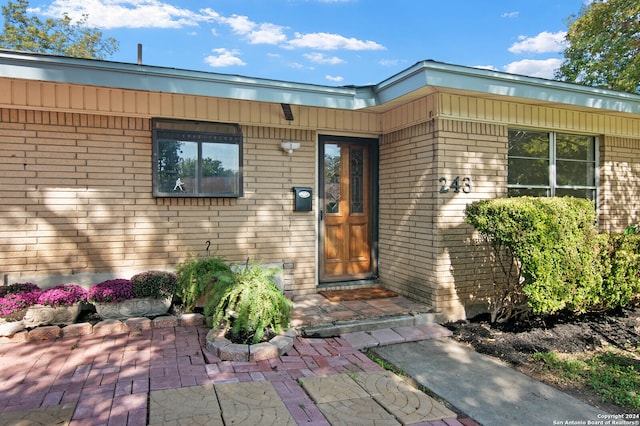 view of exterior entry featuring a patio