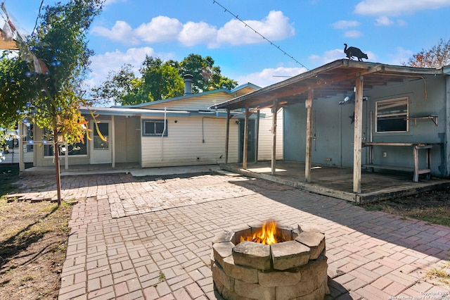 rear view of house featuring a fire pit and a patio area