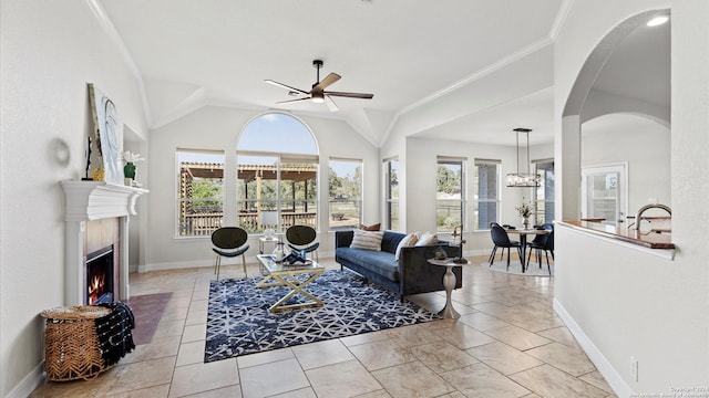 tiled living room with vaulted ceiling, ceiling fan, and ornamental molding