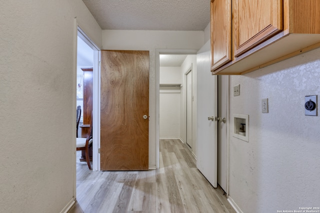 corridor featuring light hardwood / wood-style floors and a textured ceiling