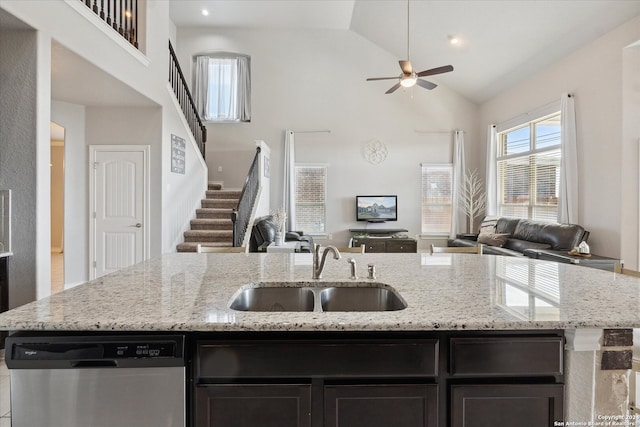 kitchen featuring light stone countertops, dishwasher, high vaulted ceiling, and sink