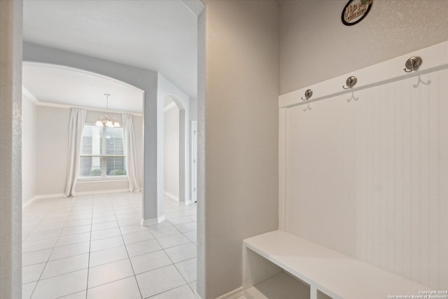 mudroom featuring light tile patterned floors and an inviting chandelier