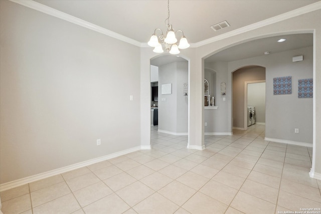 tiled spare room featuring washer / clothes dryer, ornamental molding, and an inviting chandelier