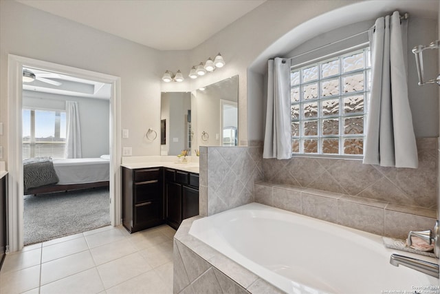 bathroom featuring tile patterned floors, tiled tub, ceiling fan, and vanity