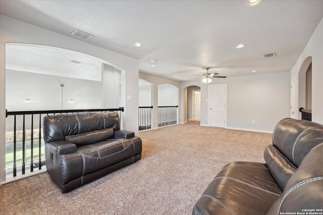 living room with ceiling fan, carpet floors, and a textured ceiling