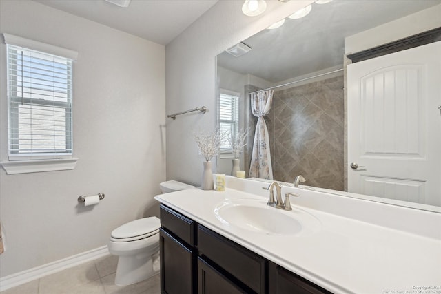 bathroom with tile patterned floors, a wealth of natural light, vanity, and toilet