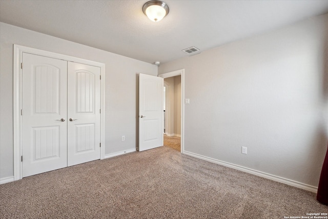 unfurnished bedroom with carpet flooring and a closet