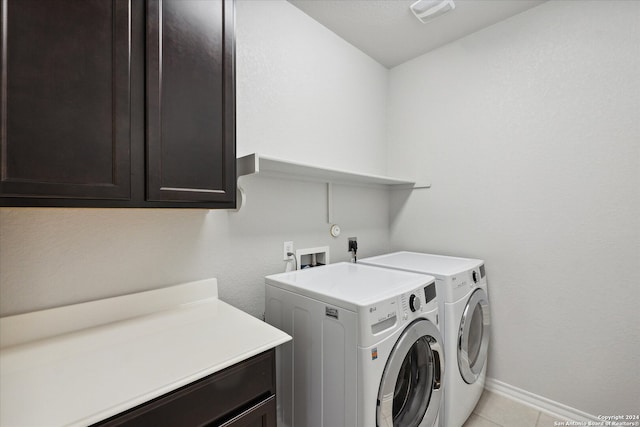 laundry area with cabinets, independent washer and dryer, and light tile patterned floors