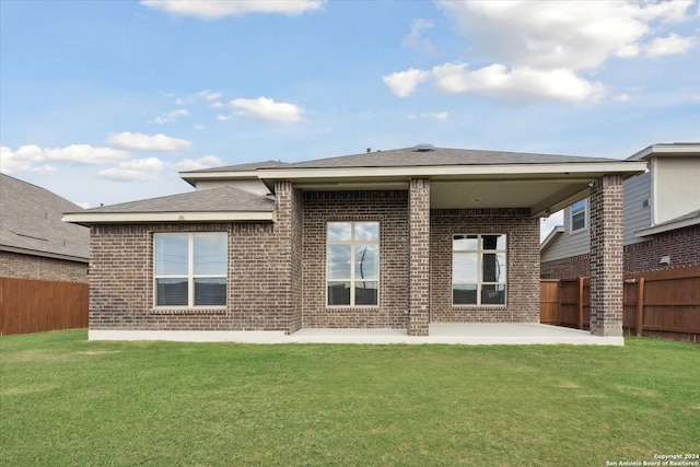 back of house featuring a patio area and a lawn