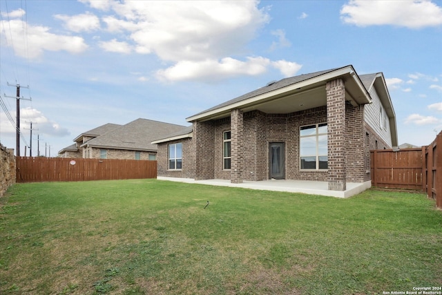 back of property featuring a lawn and a patio area