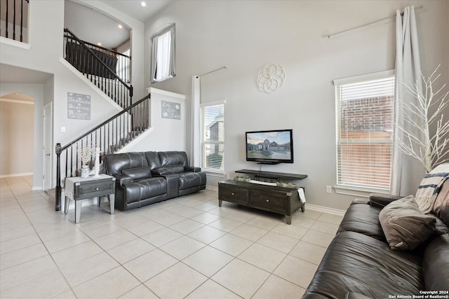 tiled living room with a healthy amount of sunlight and a high ceiling