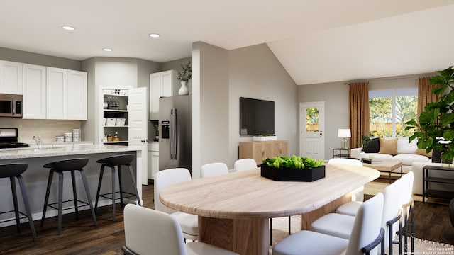 dining area featuring dark hardwood / wood-style floors, lofted ceiling, and sink