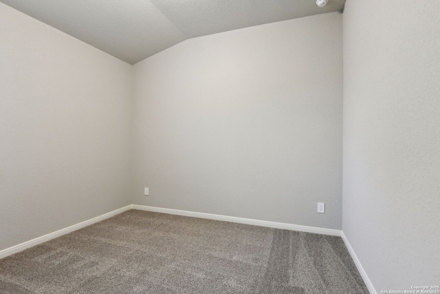 empty room featuring lofted ceiling and carpet floors