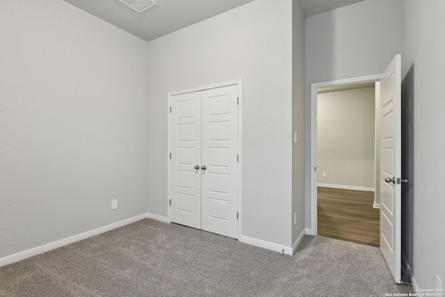 unfurnished bedroom with a closet and carpet flooring