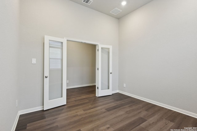 spare room with dark hardwood / wood-style flooring and french doors