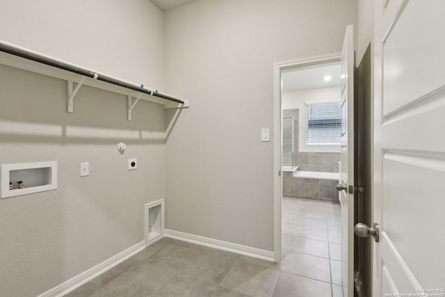 laundry area with hookup for a washing machine, light tile patterned flooring, hookup for an electric dryer, and hookup for a gas dryer