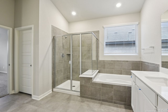 bathroom featuring tile patterned flooring, vanity, and plus walk in shower