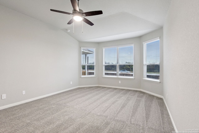 carpeted spare room with ceiling fan and vaulted ceiling