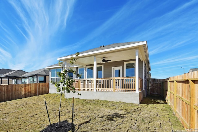 back of house with ceiling fan, a porch, and a yard