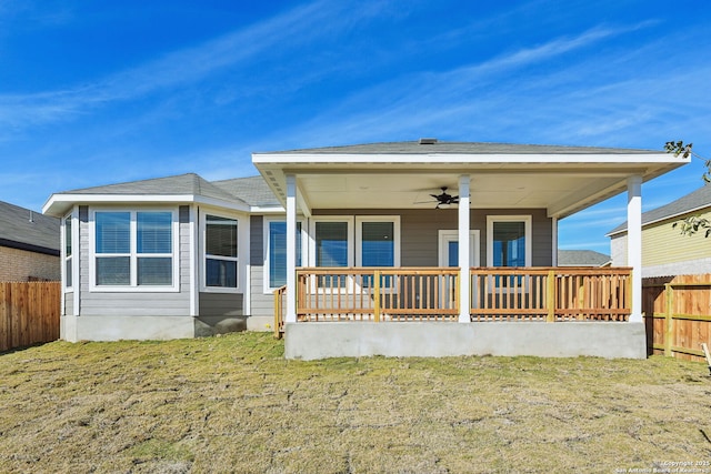 back of property featuring a yard, ceiling fan, and covered porch