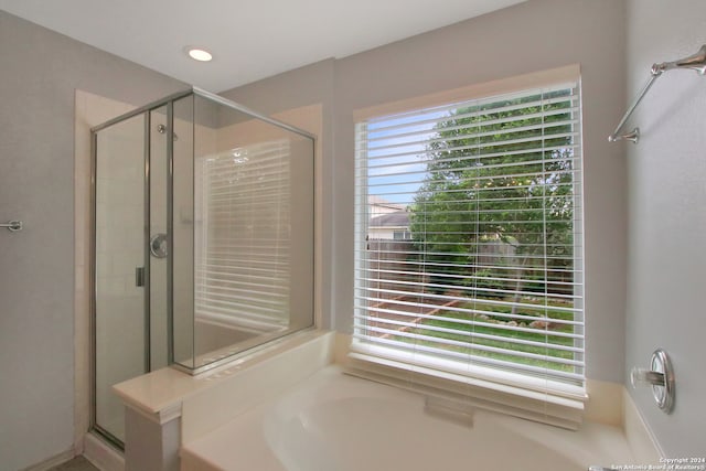 bathroom featuring shower with separate bathtub and a wealth of natural light