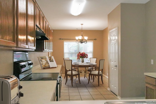 kitchen featuring a chandelier, light tile patterned floors, range with electric cooktop, and hanging light fixtures