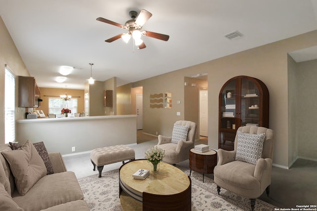 living room with ceiling fan with notable chandelier and light carpet