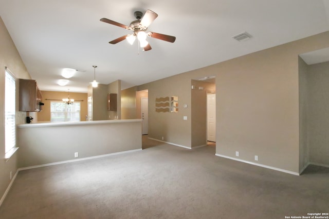 interior space featuring carpet and ceiling fan with notable chandelier