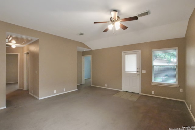 unfurnished living room with ceiling fan, dark carpet, and vaulted ceiling