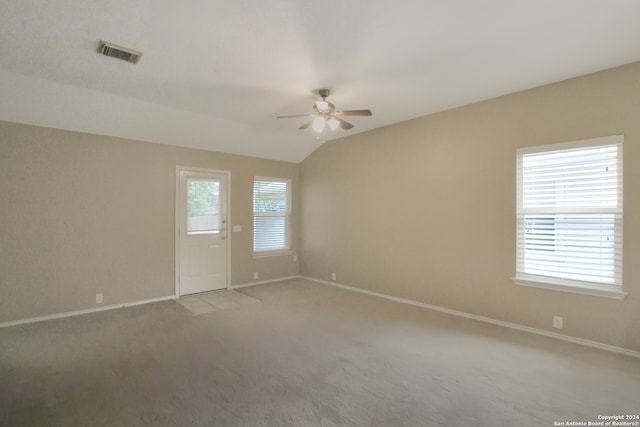 unfurnished room with ceiling fan, light colored carpet, a healthy amount of sunlight, and lofted ceiling