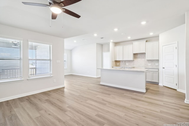 kitchen with light hardwood / wood-style flooring, white cabinetry, and sink