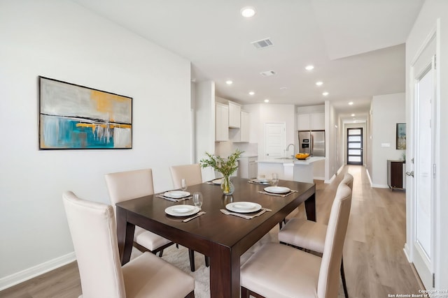 dining space featuring light hardwood / wood-style floors and sink